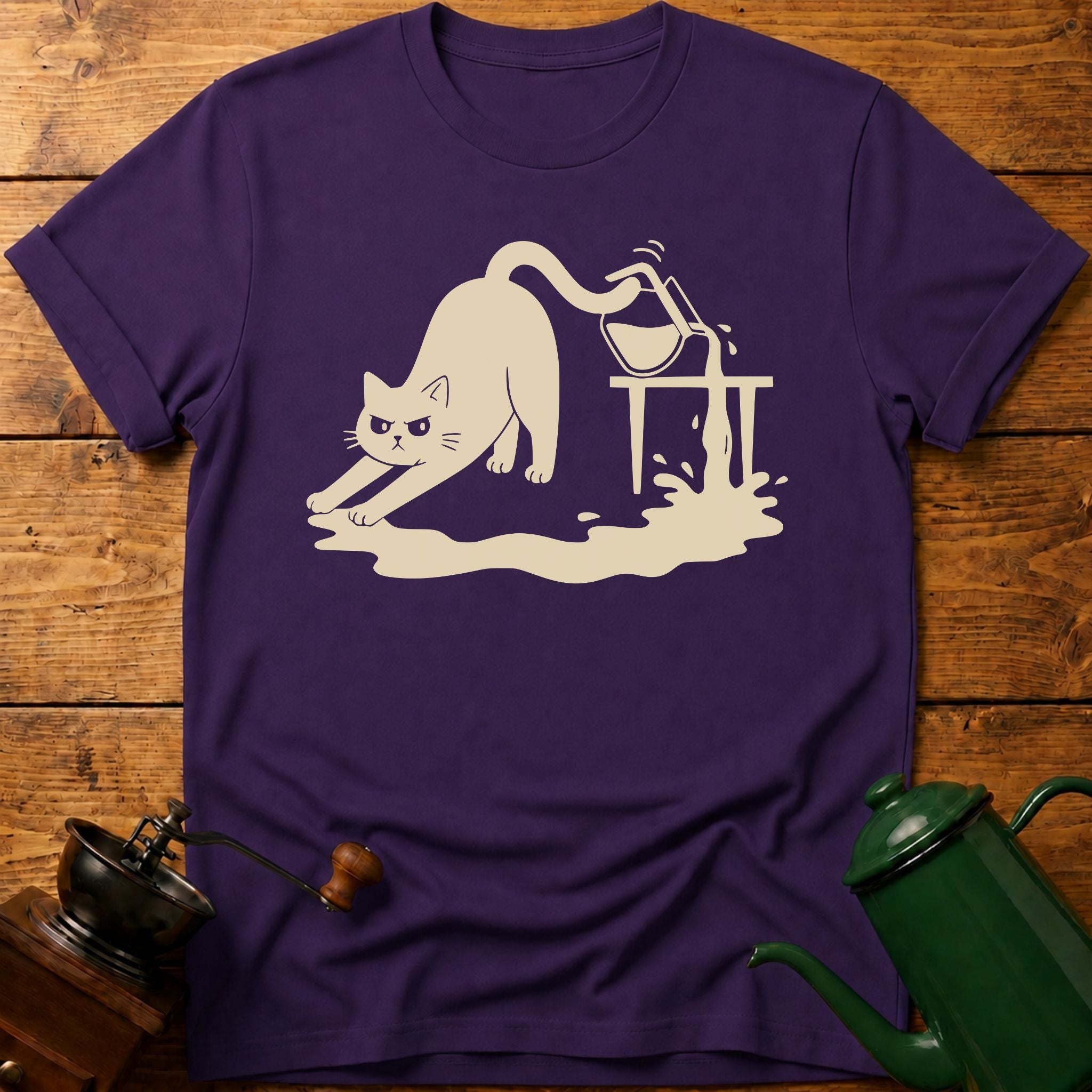 Purple t-shirt with a white cat graphic on a wooden surface